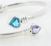 Close up of heart-shaped blue and purple gemstones on a white background